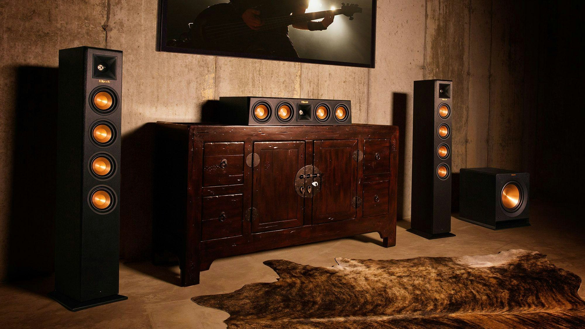 Klipsch wireless speakers flanking a tv and wood cabinet