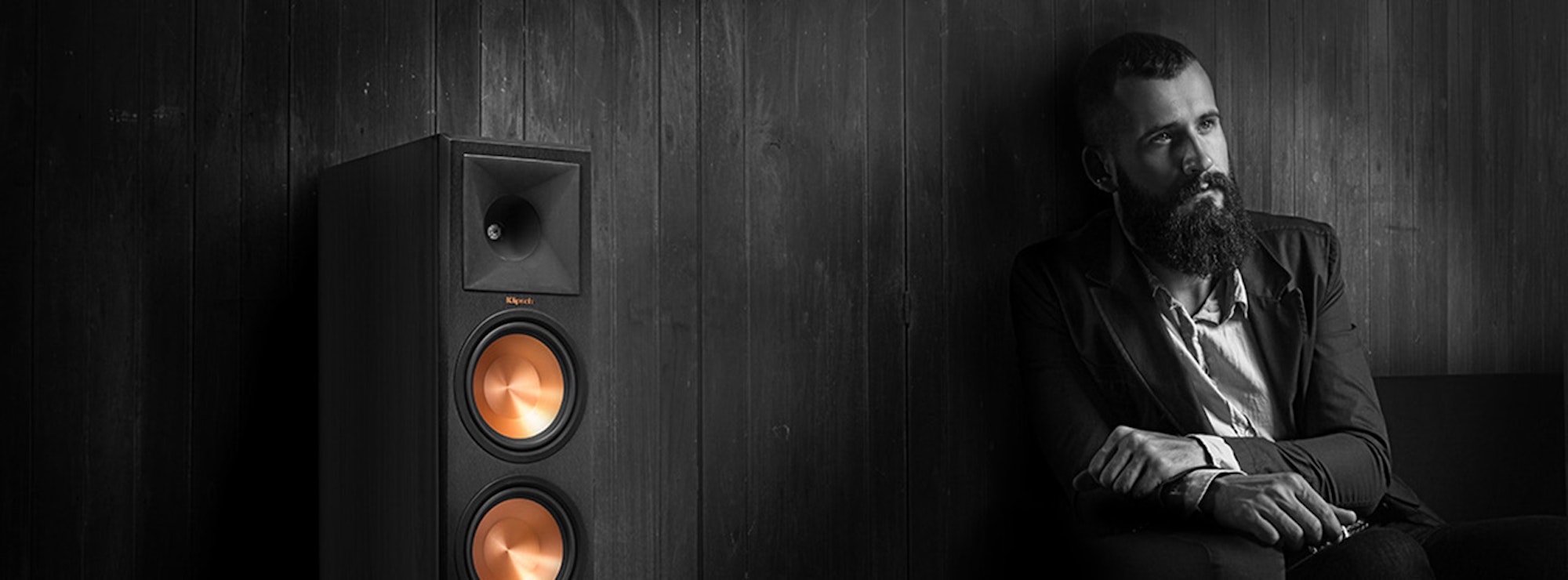 Guy sitting and listening to Klipsch floorstanding speaker