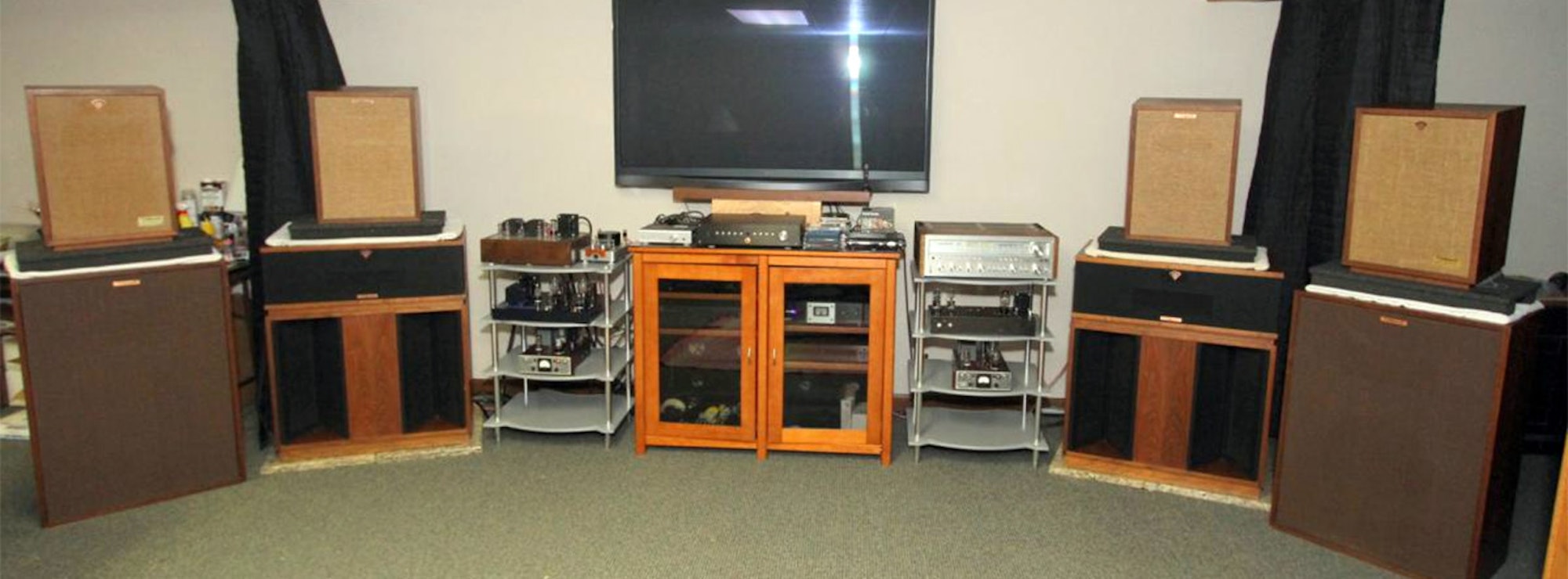 A variety of Klipsch speakers surrounding a tv