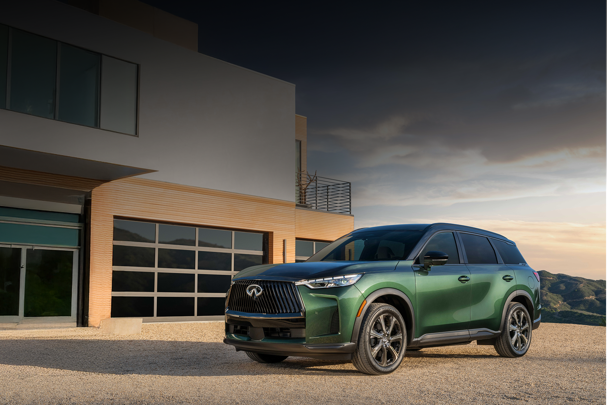 2026 INFINITI QX60 green in front of large modern home 2000x1333