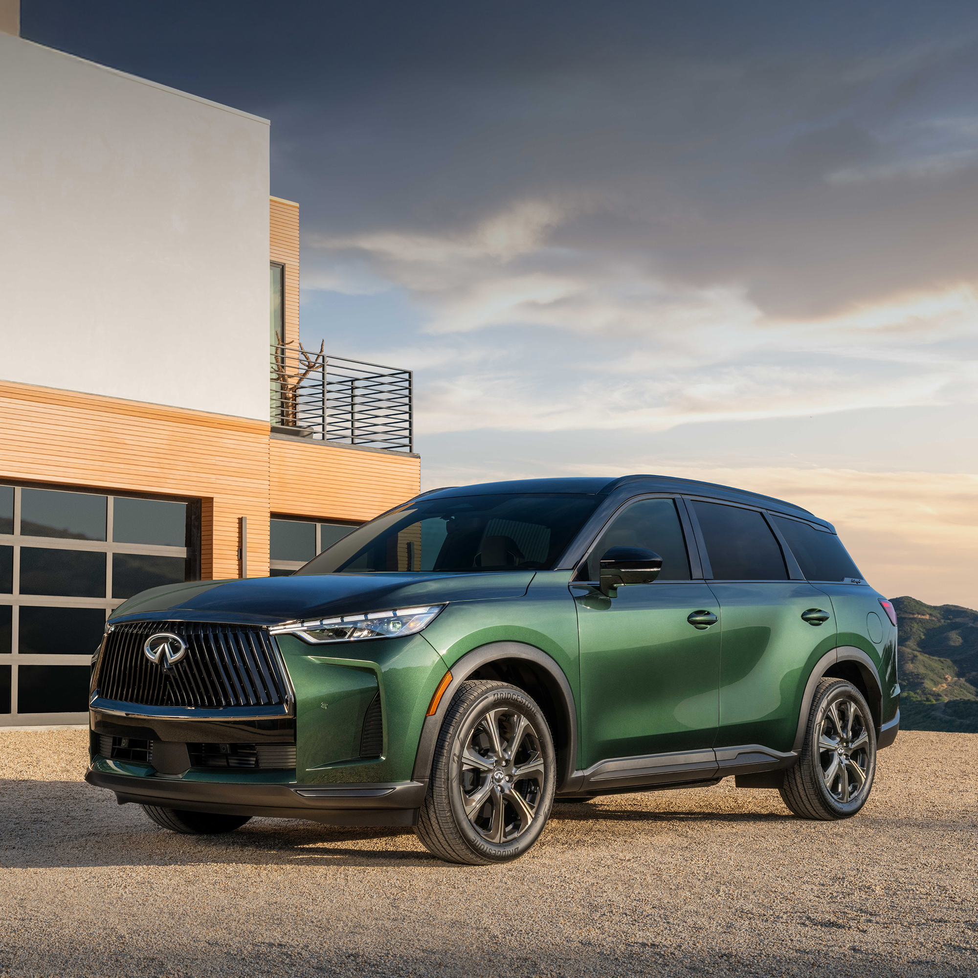 2026 INFINITI QX60 green in front of large modern home 2000x2000