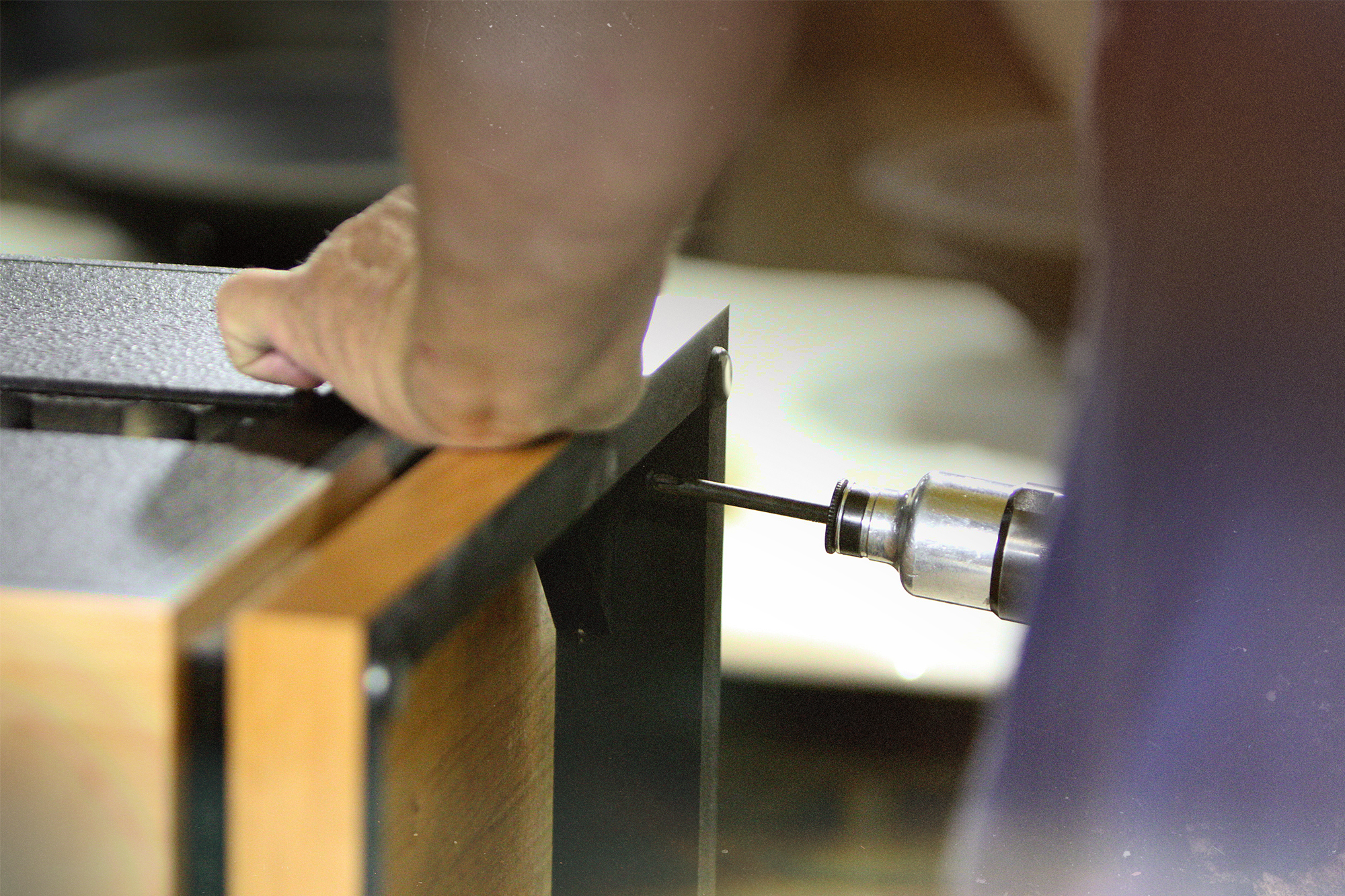 A close up view of a craftsman at the Hope Arkansas Klipsch Factory hand assembling a Heritage Speaker with a screwgun LAS 2000x1333