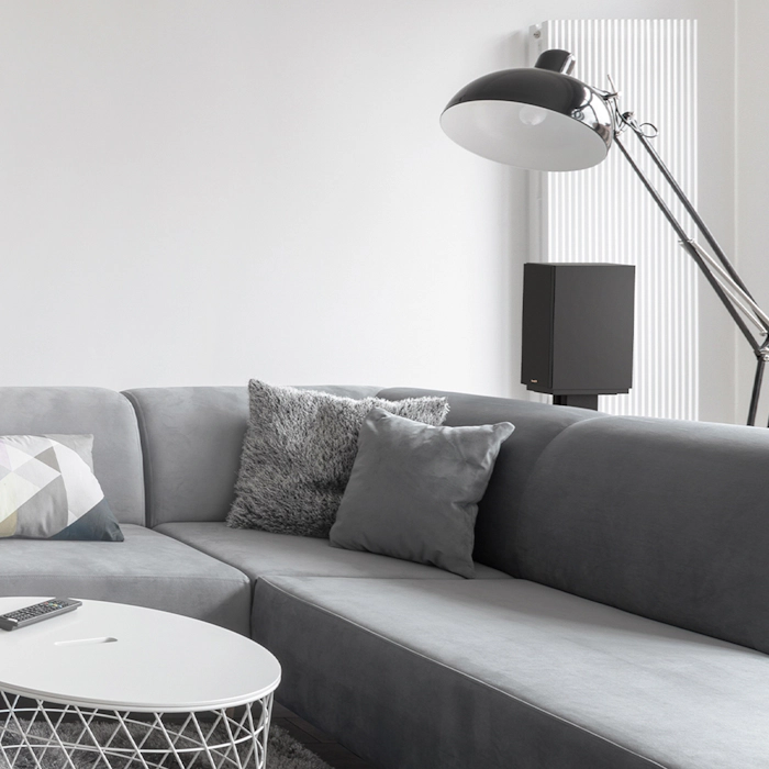 KD 51 M Speaker on a stand behind a grey sectional sofa mobile