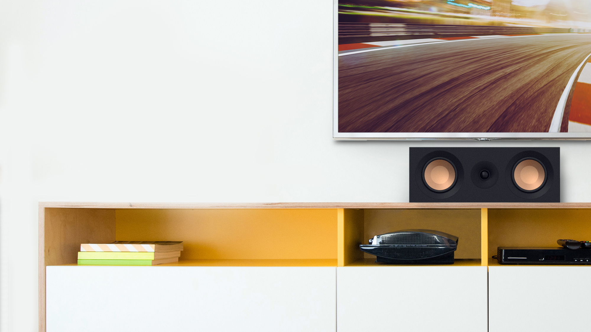 KD 52 C on a white and yellow credenza under a TV with grille off