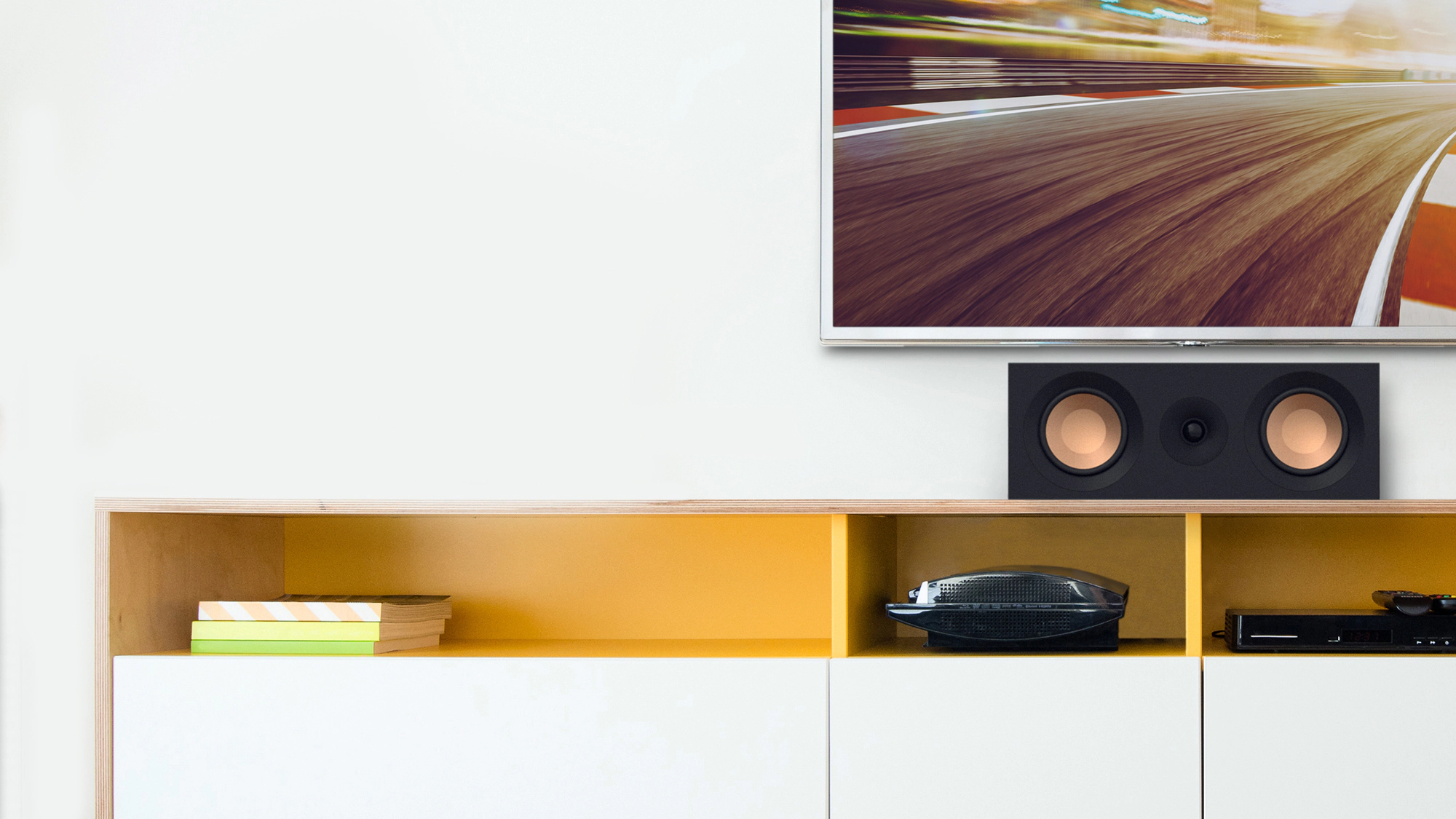 KD 52 C on a white and yellow credenza under a TV with grille off