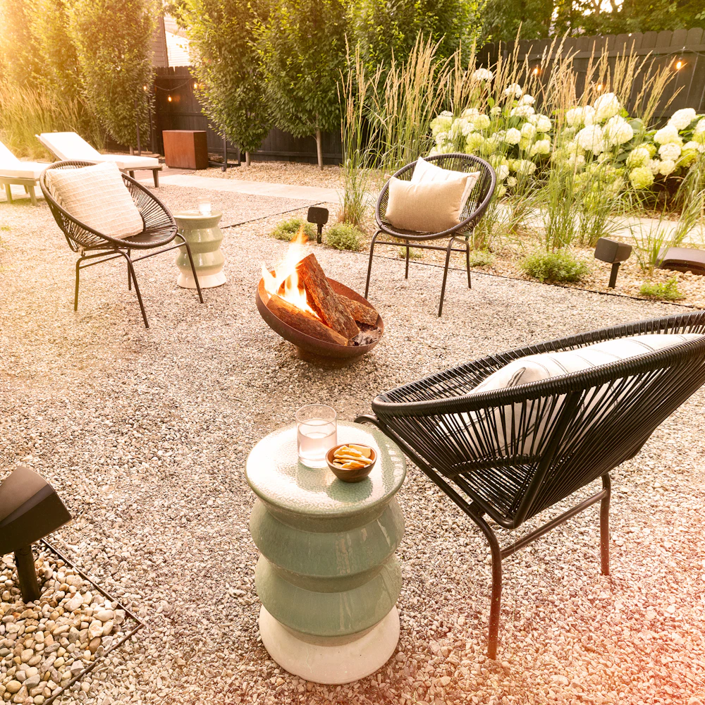 Klipsch Courtyard Speakers outside on cozy patio with fire pit at golden hour 2000x2000