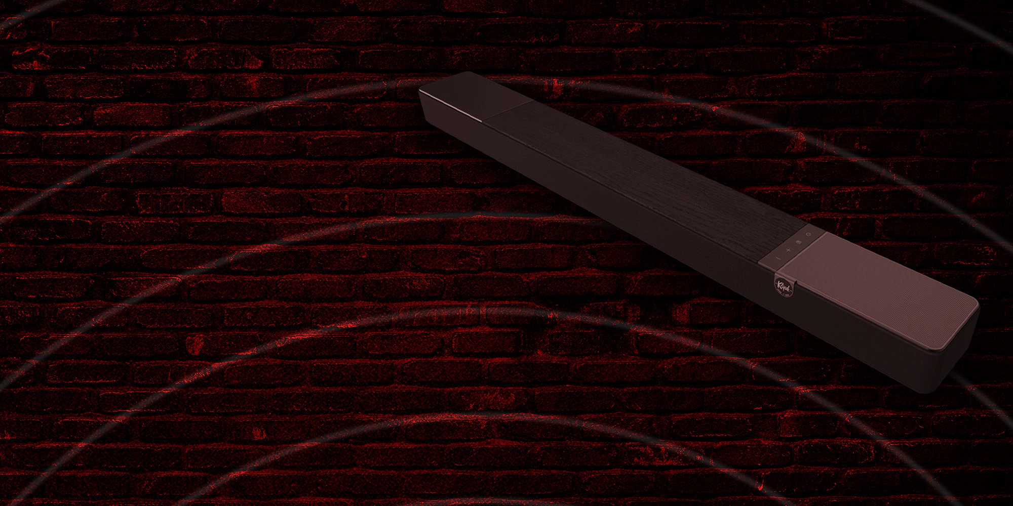 Klipsch Daredevil Partnership Flexus Core against dark red brick wall with circles emanating 2000x1000