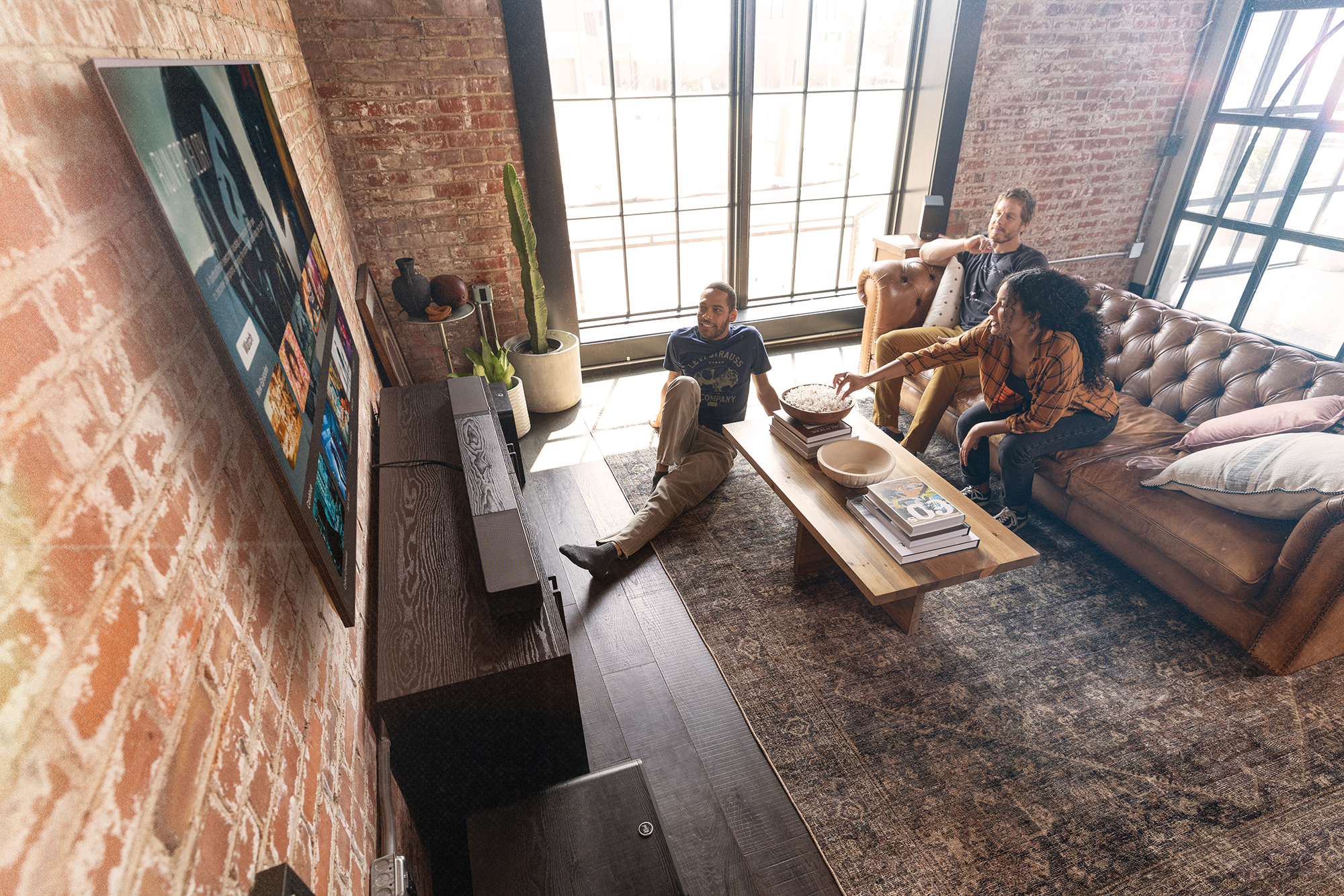 Klipsch Flexus Core 300 Sub 200 Surr 200 in brick loft with friends engaged watching tv 2000x1333