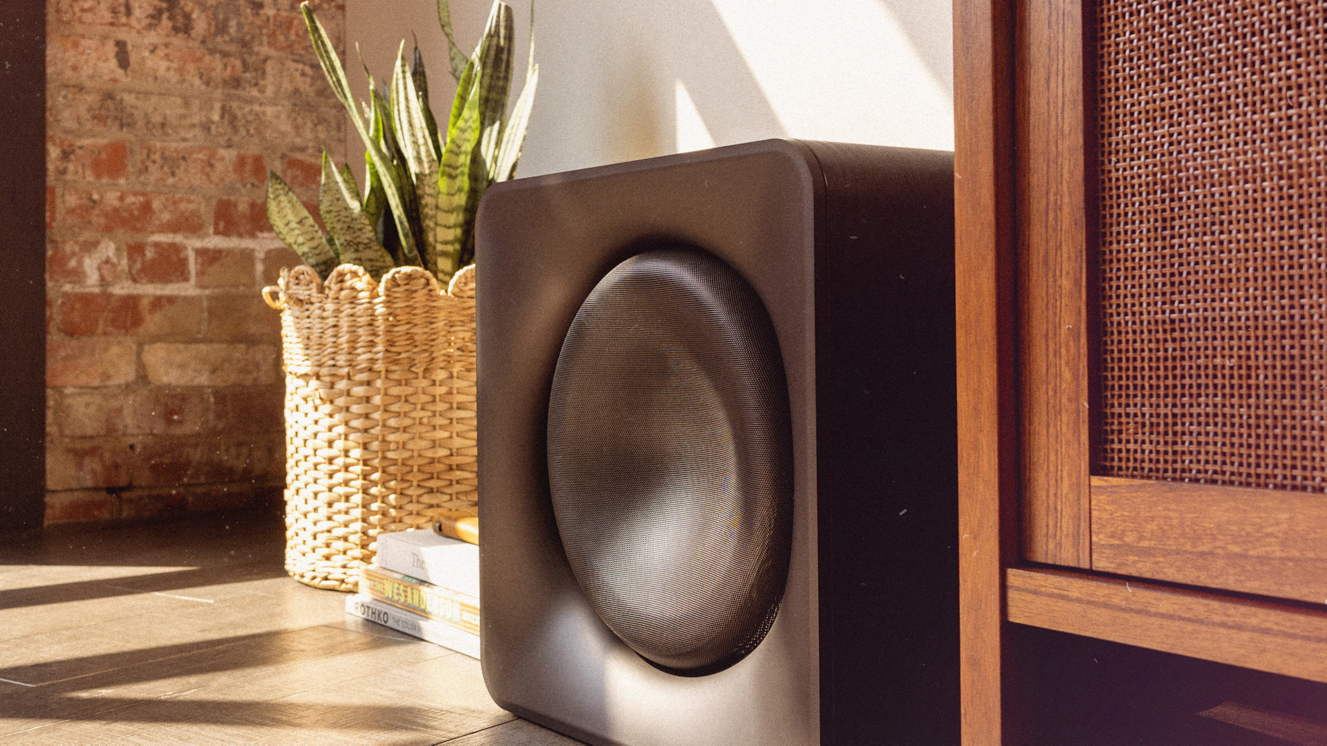 Klipsch Flexus SUB 200 in sunny living room beside snake plant in basket and media console 2000x2000