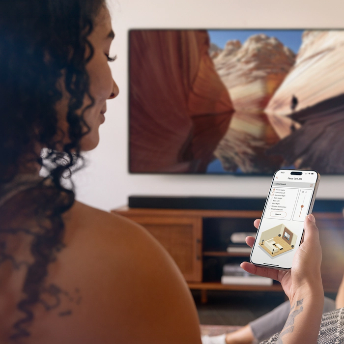 Klipsch Flexus woman using Klipsch Connect Plus app to control her Core 300 2000x2000