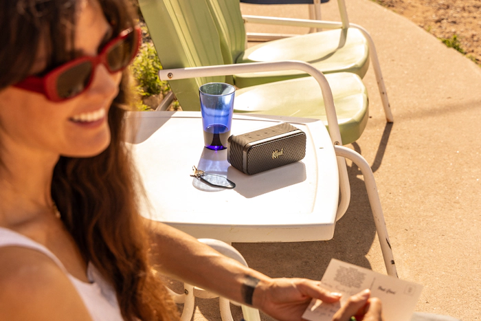 Klipsch Nashville Portable Bluetooth Speaker on sun soaked side table on motel patio 2000x1333