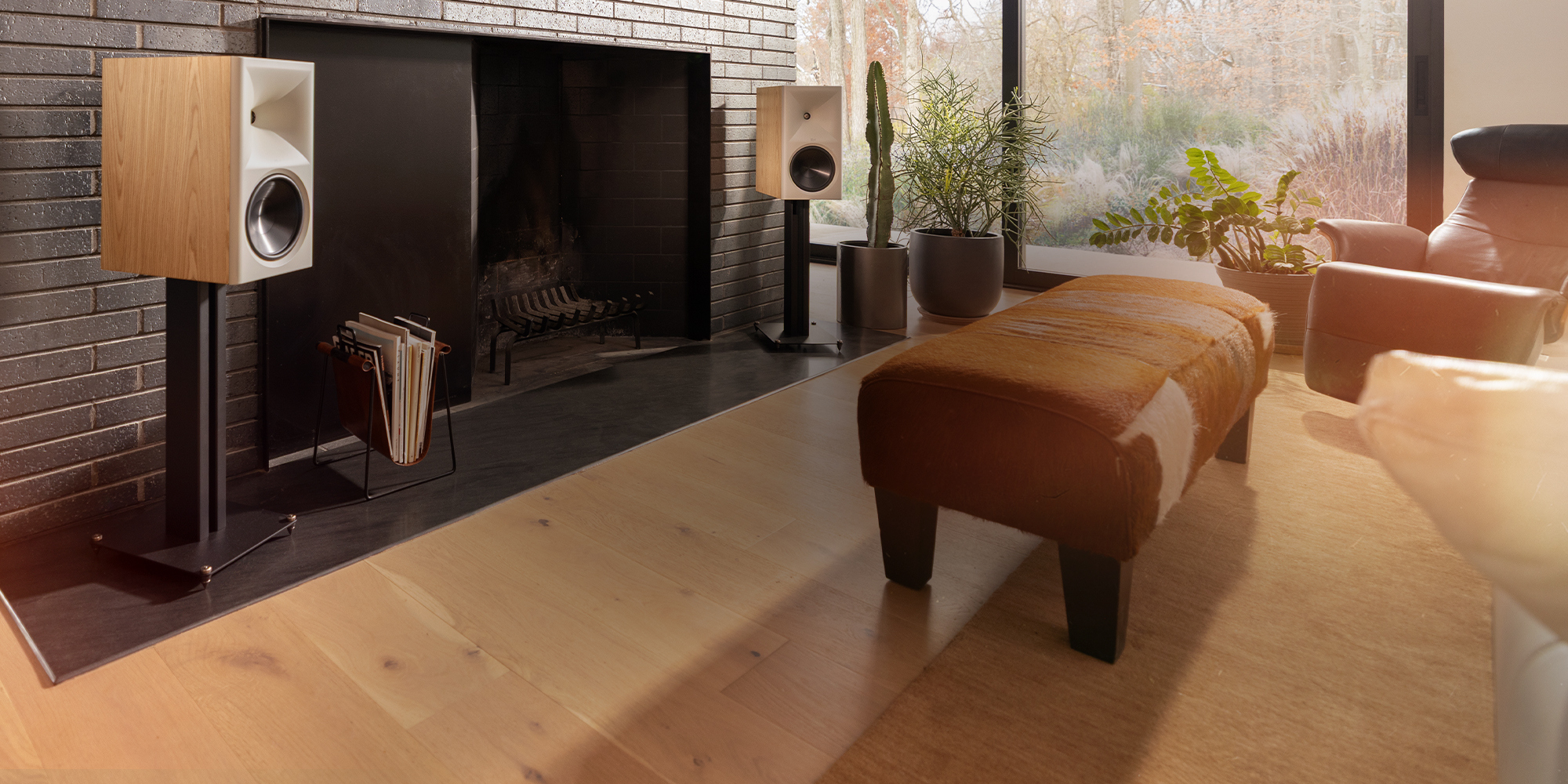 Klipsch Nines II Red Oak on Klipsch speaker stands flanking grey brick wall with fireplace and tv art in modern 2000x1000