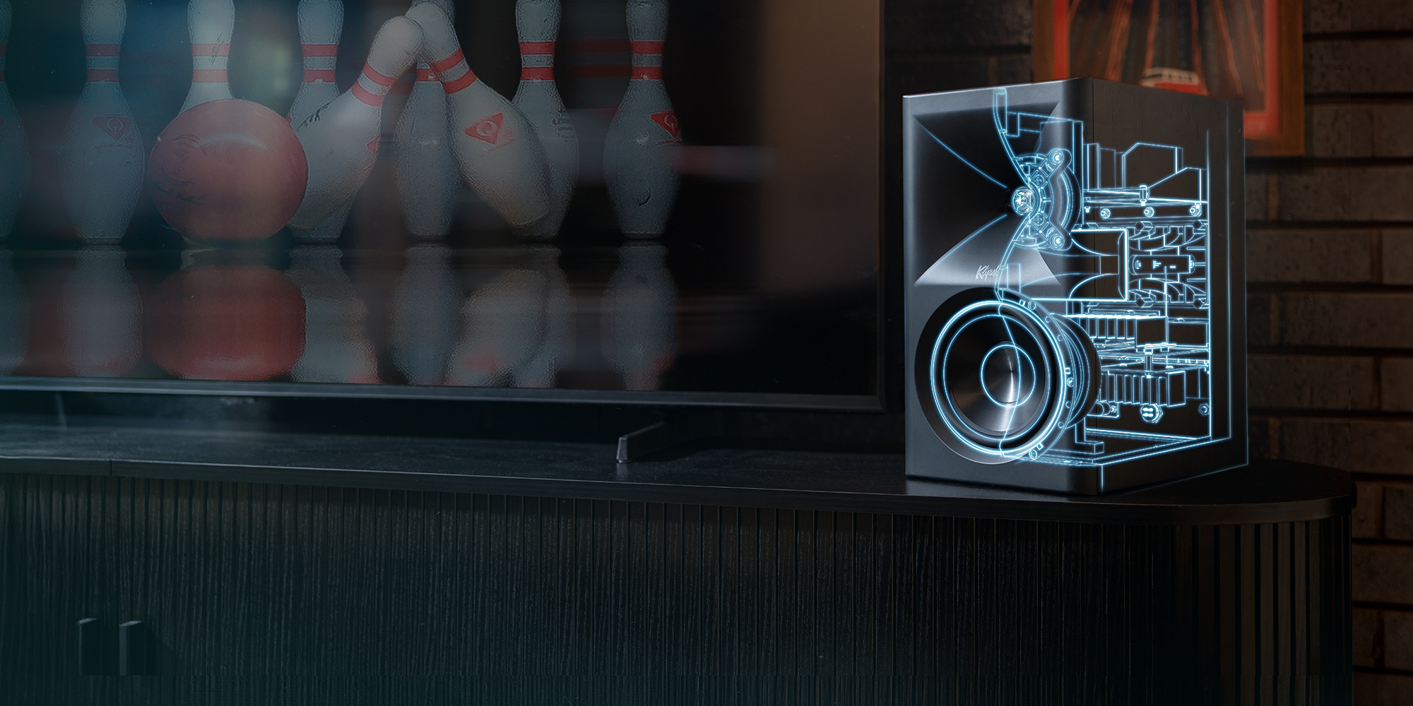 Klipsch The Fives II is powered by Onkyo beside tv with line drawing tech overlay in Onkyo blue 2000x1000