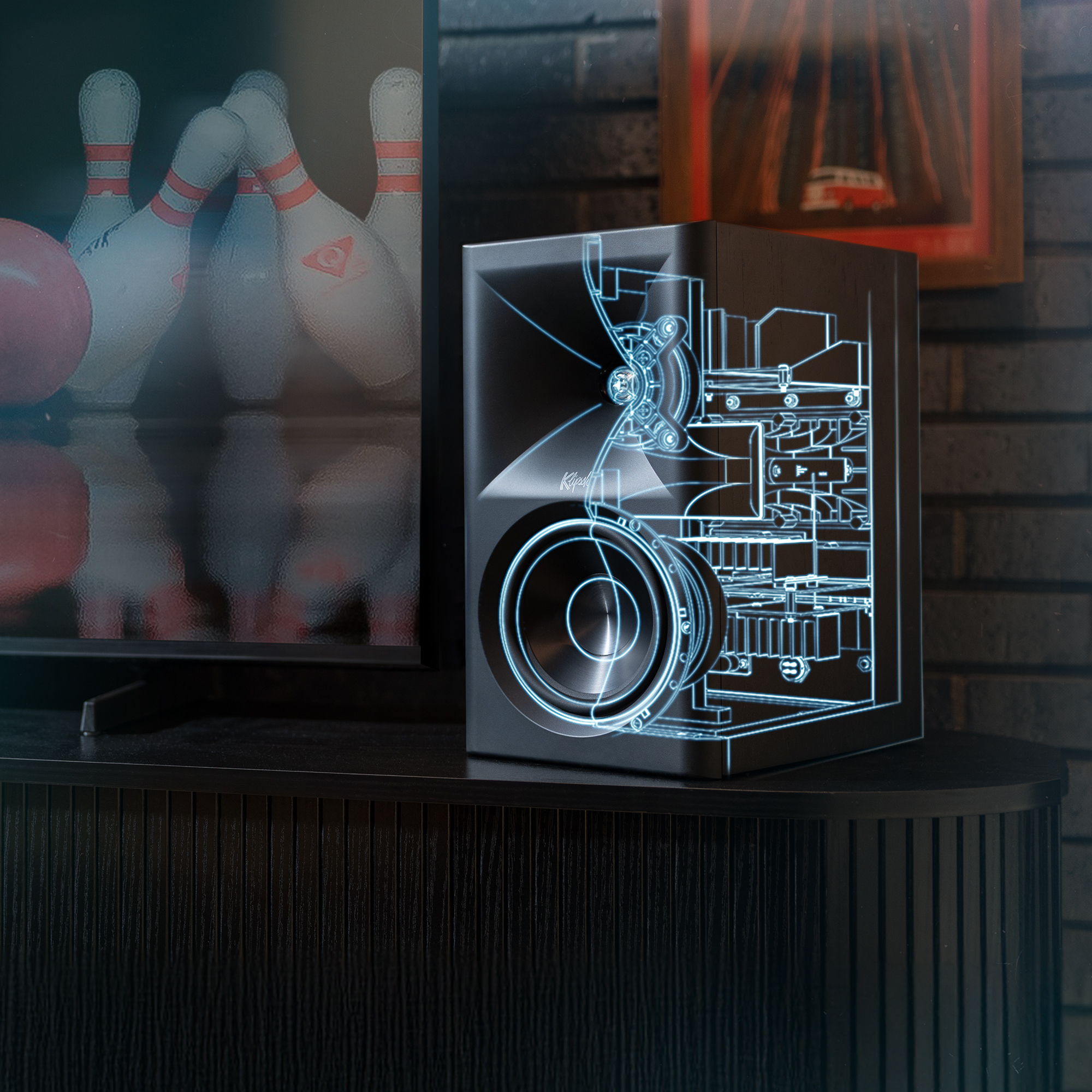 Klipsch The Fives II is powered by Onkyo beside tv with line drawing tech overlay in Onkyo blue 2000x2000