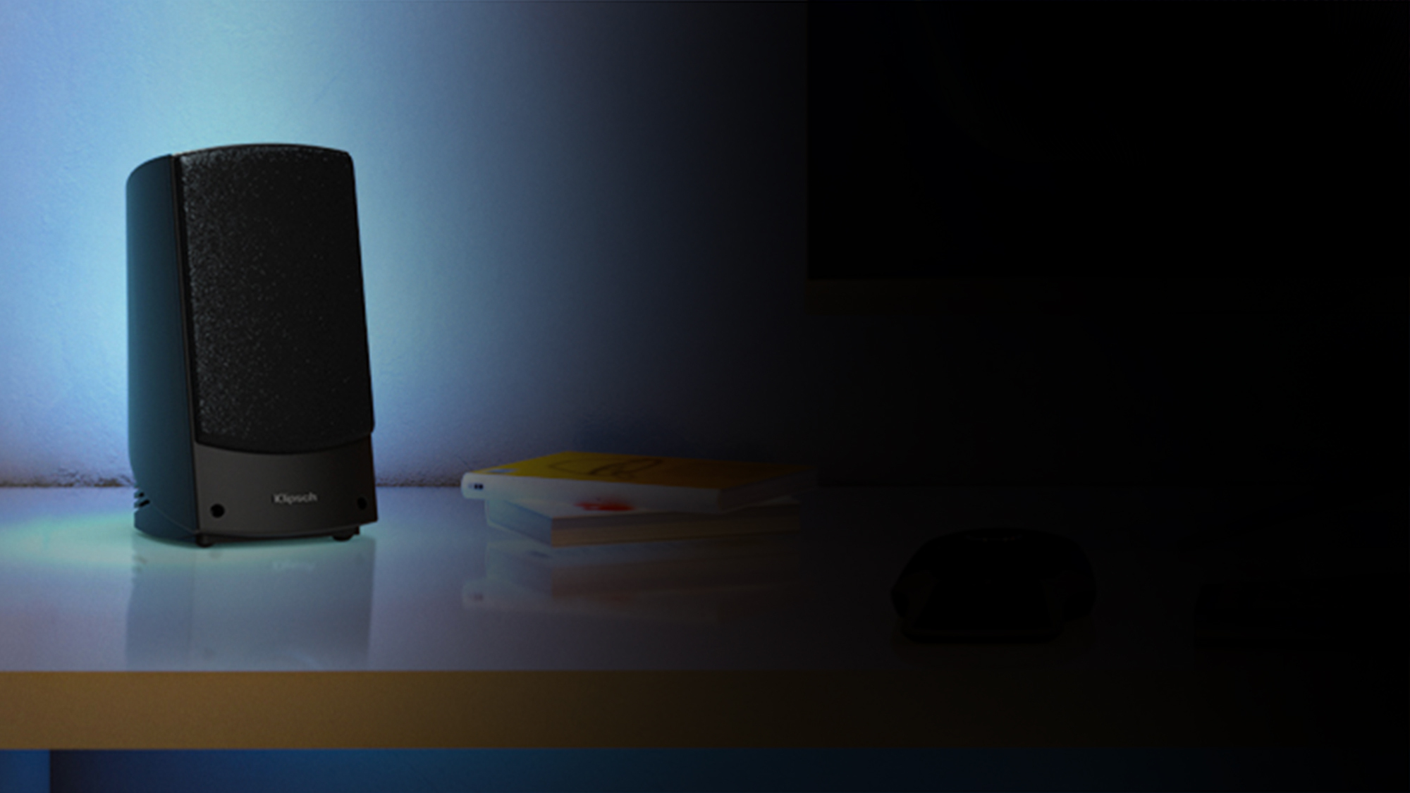 Promedia 2 0 Speaker on a table next to books