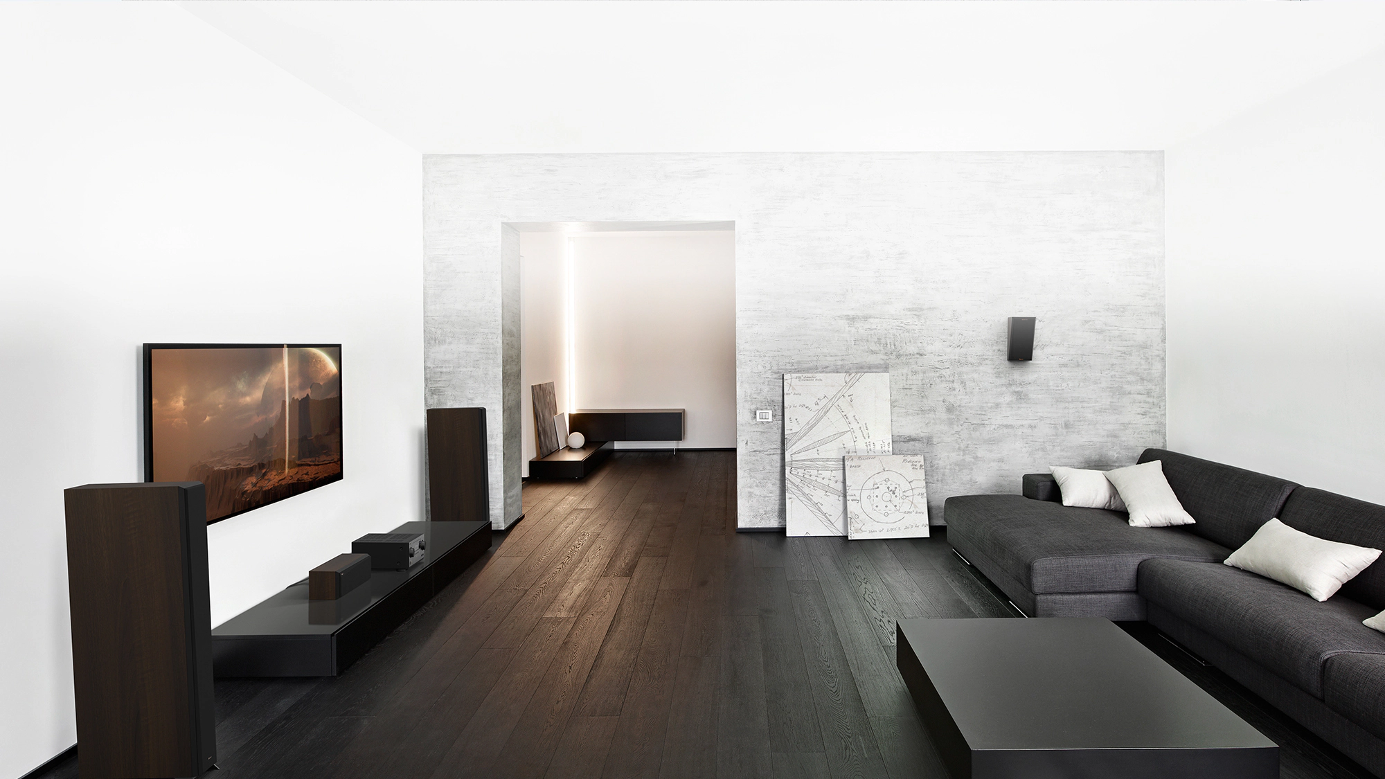 RP 6000 F speakers in a home theater setting with dark grey and black furniture