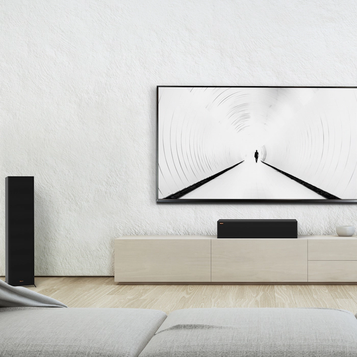 RP 8060 FA II speakers flanking a center channel speaker and TV against a white wall mobile