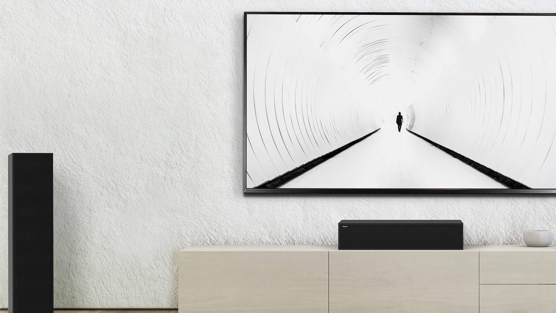 RP 8060 FA II speakers flanking a center channel speaker and TV against a white wall mobile