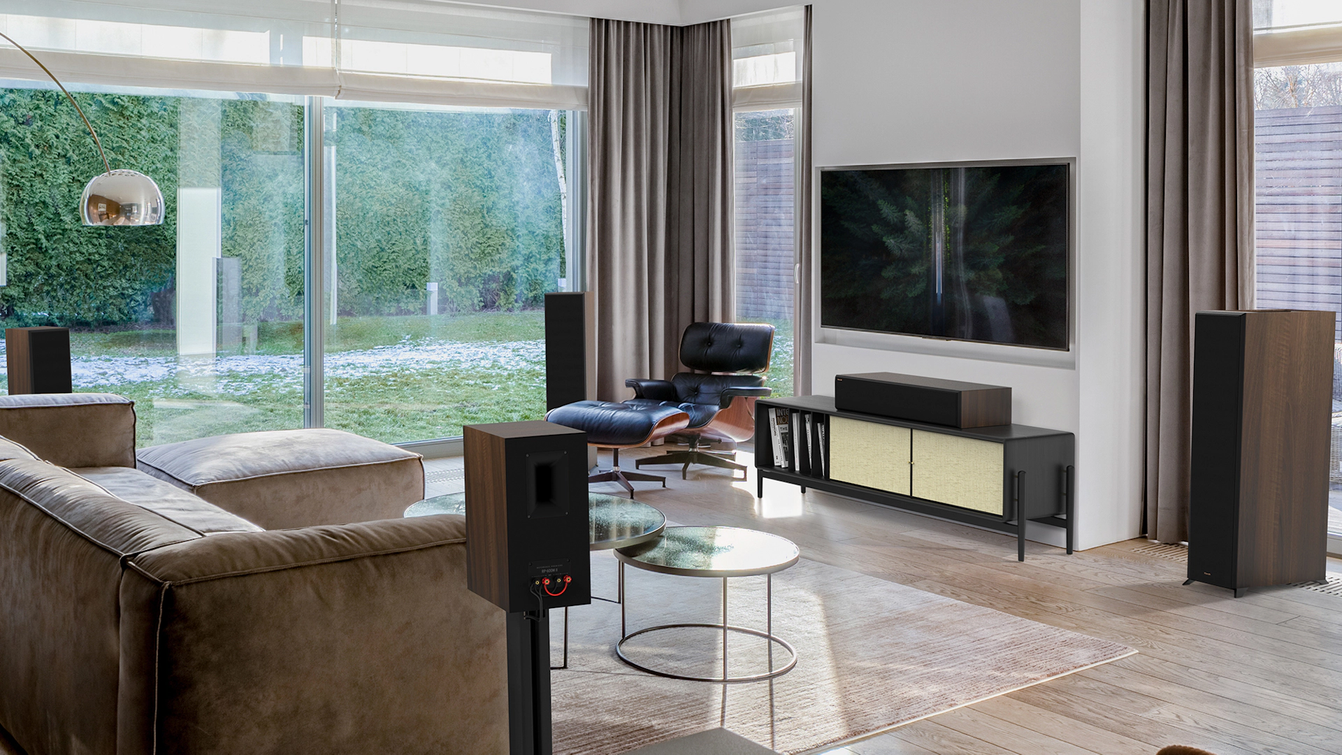 Reference Premiere II Series Home Theater Speakers with a walnut finish in a living room setting with brown furniture mobile