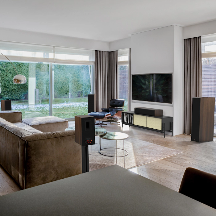 Reference Premiere II Series Home Theater Speakers with a walnut finish in a living room setting with brown furniture mobile