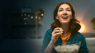 Woman smiling while enjoying popcorn