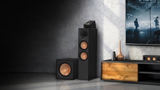Reference Home Theater Speakers with an Atmos topper next to a dark grey and wooden credenza