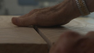 A man's hands on a wooden surface