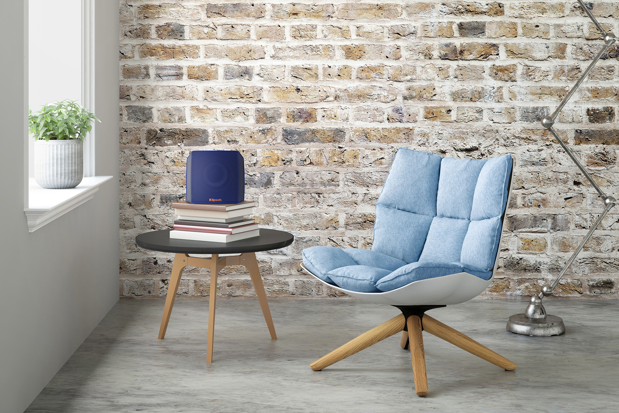 Klipsch Groove blue portable wireless speaker next to chair