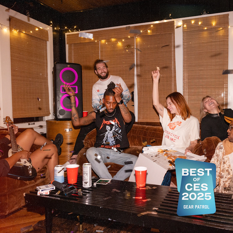 Klipsch New York Party Speaker in apartment party with friends grooving and silver confetti falling and pizza and beverages on table with Gear Patrol Best of CES 2025 badge 2000x2000