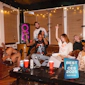 Klipsch New York Party Speaker in apartment party with friends grooving and silver confetti falling and pizza and beverages on table with Gear Patrol Best of CES 2025 badge 2000x2000