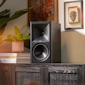 Klipsch The Sevens BK on modern media console beside plant and Americana art with warm lighting 2000x2000
