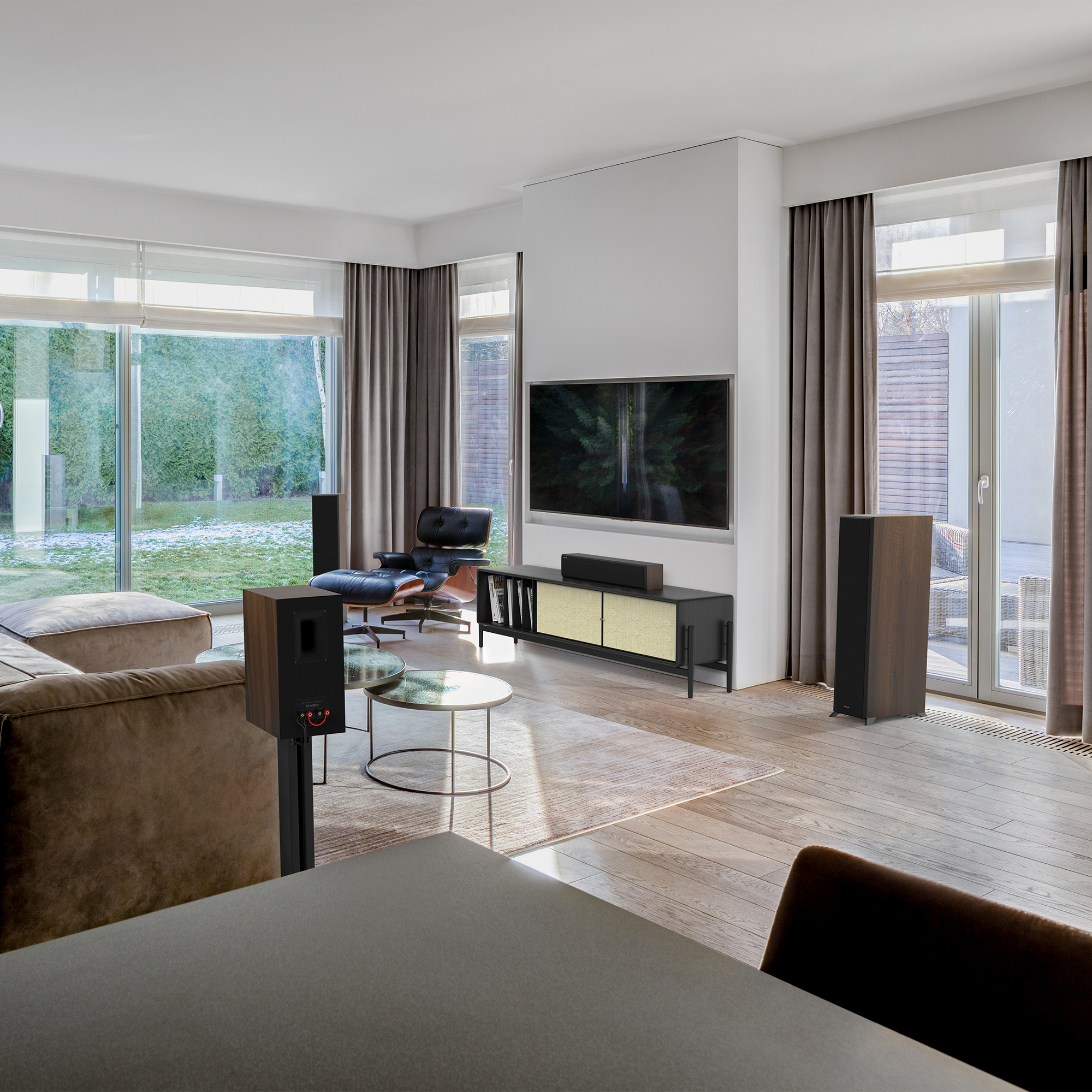 RP 404 C II sitting on a black and beige wooden credenza under a TV with its grille on in a living room setting