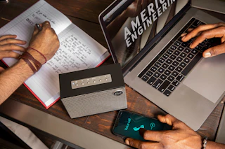 A Klipsch Heritage Groove tabletop stereo next to a computer