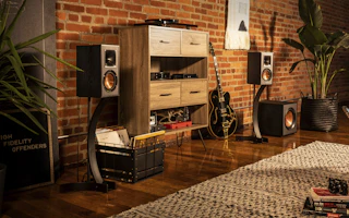 Klipsch speakers with a guitar and wooden shelf